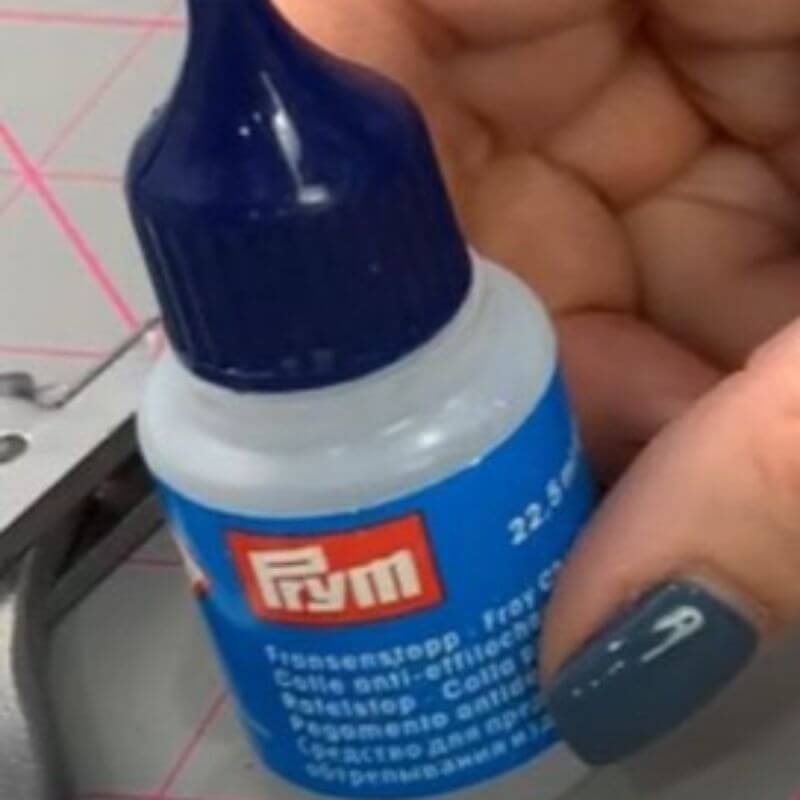 A photo of fray checker in a clear bottle with blue cap.
